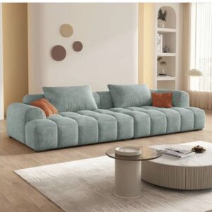 A modern, gray fabric sofa with wooden legs, featuring plush cushions and a sleek design, placed in a well-lit living room with a minimalist decor."