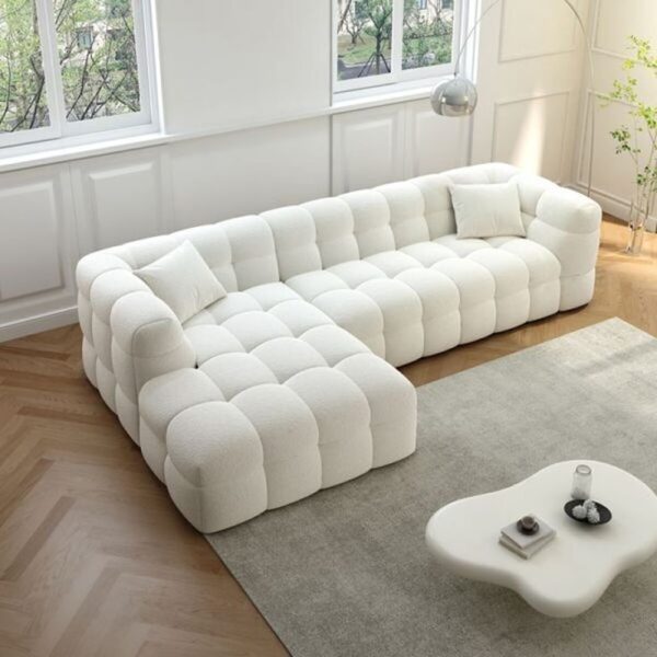 A cozy, puffy sofa with overstuffed cushions and rounded edges, upholstered in a soft, plush fabric.