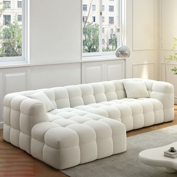 A cozy, puffy sofa with overstuffed cushions and rounded edges, upholstered in a soft, plush fabric.